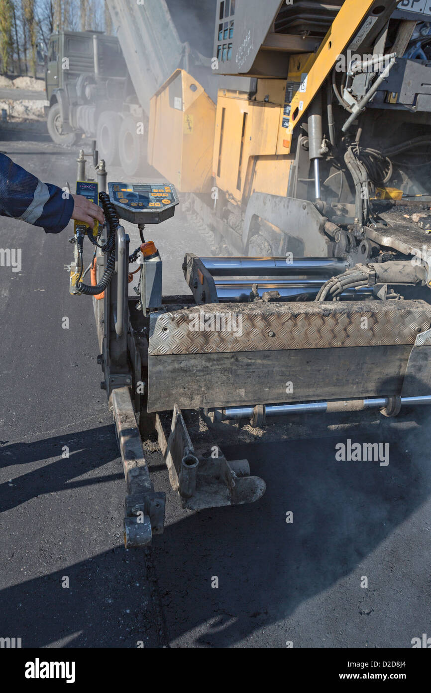 Große Straße auftauchen Maschine wird gefolgt von Sattelschleppers Arbeiter Stockfoto