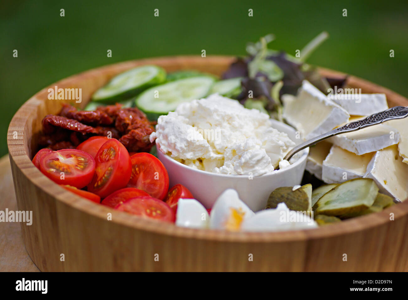 Eine hölzerne Salatschüssel mit verschiedenen Gemüse und Käse gefüllt Stockfoto