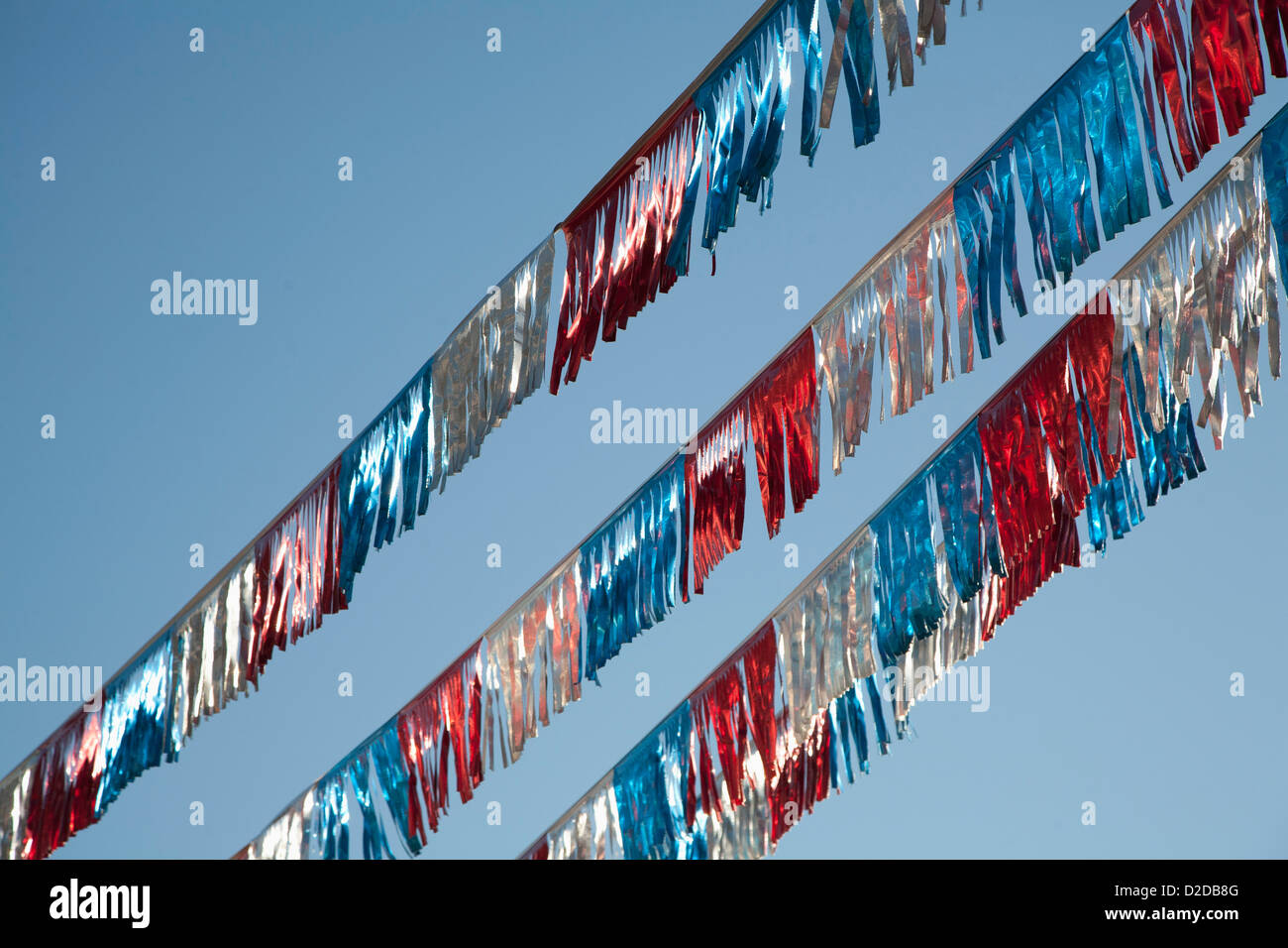 Amerikanische Flagge farbige Luftschlangen vor einem strahlend blauen Himmel Stockfoto