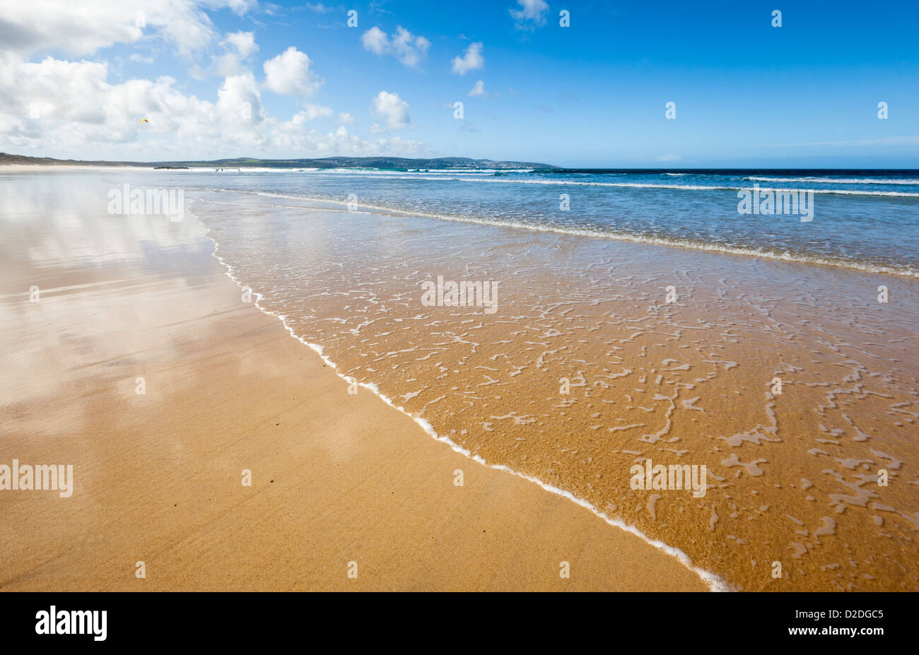 Surfen Sie sanft brechen am sandigen Strand von Gwithian in Cornwall, Großbritannien. Stockfoto