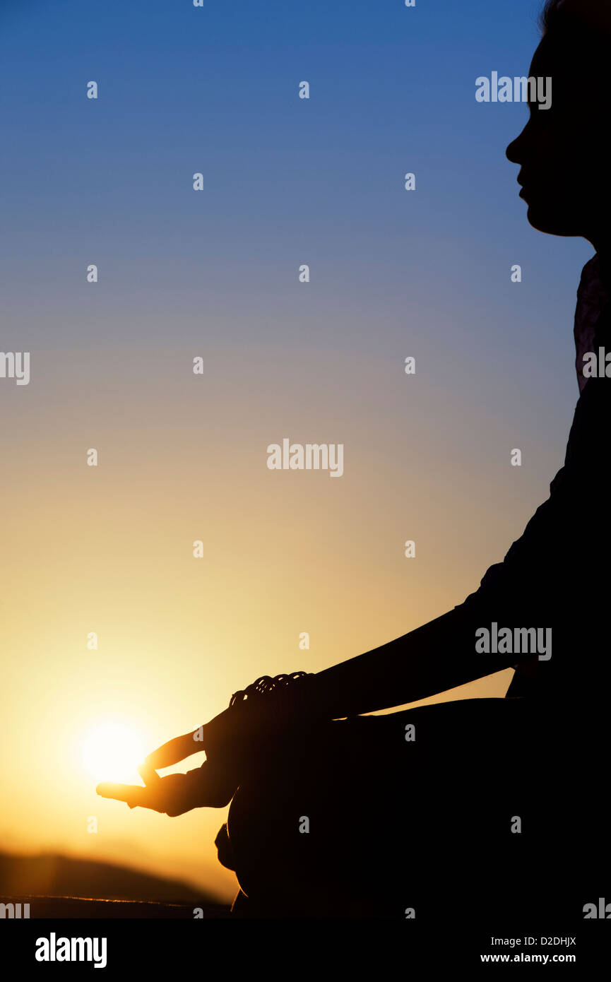 Sonnenuntergang Silhouette eines indischen Mädchen meditieren. Andhra Pradesh, Indien Stockfoto