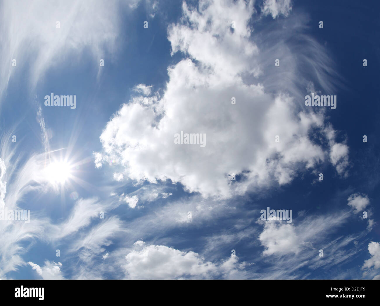 Blauer Himmel mit Wolken und Sonne. Stockfoto