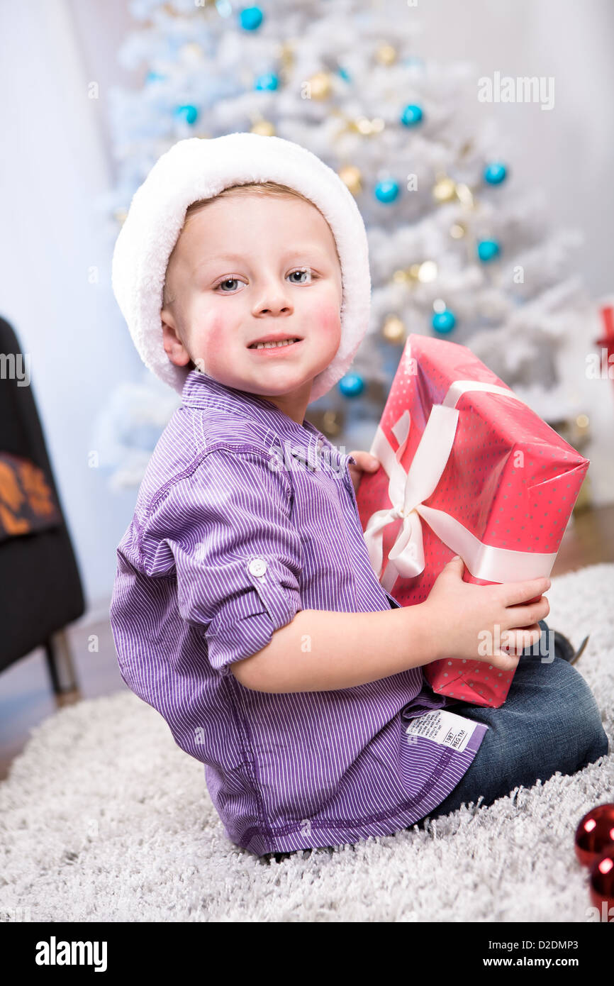 Innenaufnahme eines kleinen Jungen mit Weihnachtsgeschenk Stockfoto