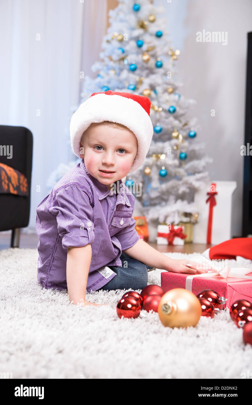 Innenaufnahme eines kleinen Jungen mit Weihnachtsgeschenk Stockfoto