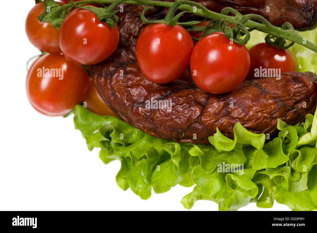 geräucherte Wurst mit Salat und Kirschtomaten Stockfoto