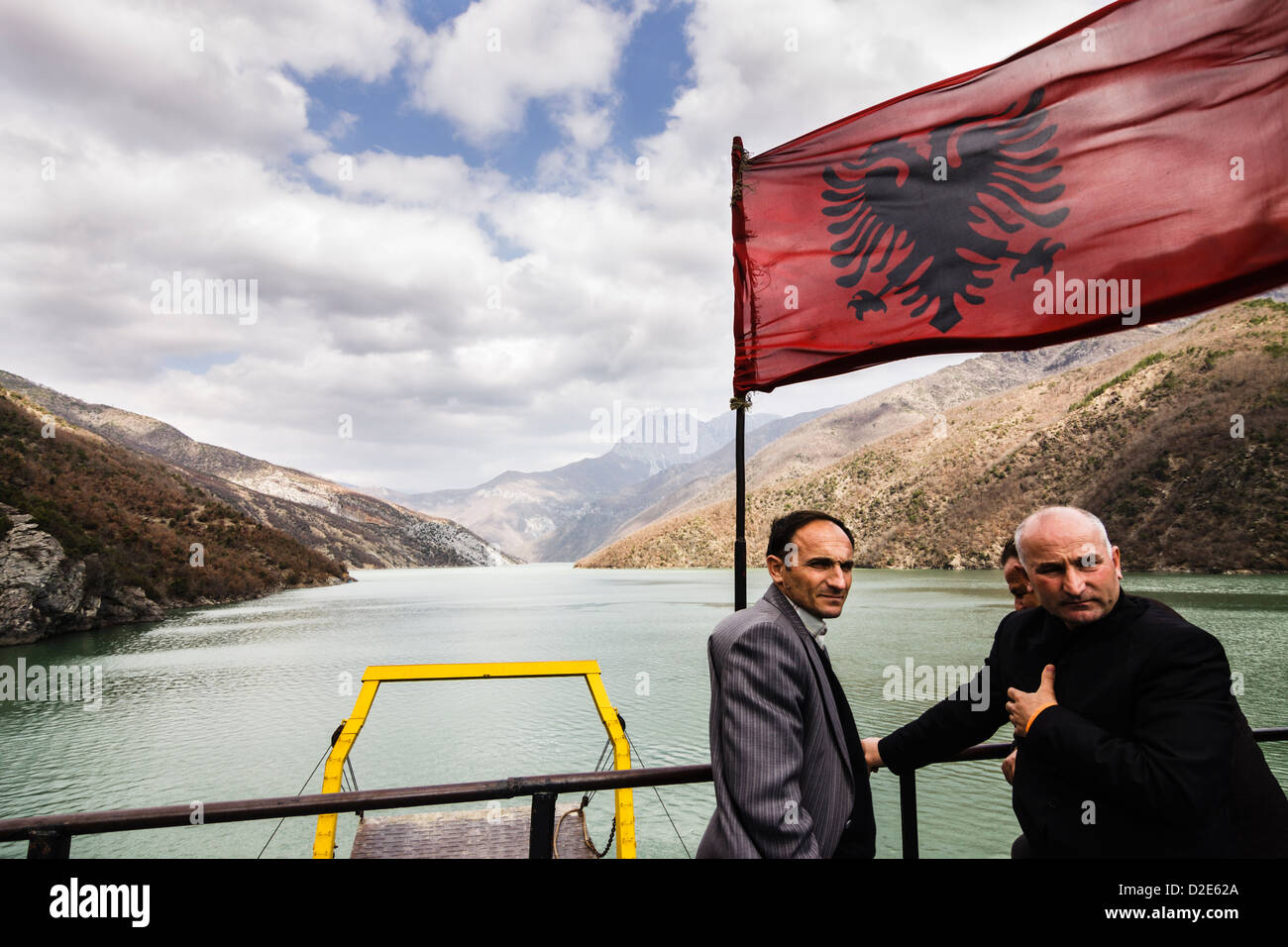 Mit der Fähre Passagiere neben der albanischen Flagge am Bug der Komani-Fierze Seen. Albanien Stockfoto