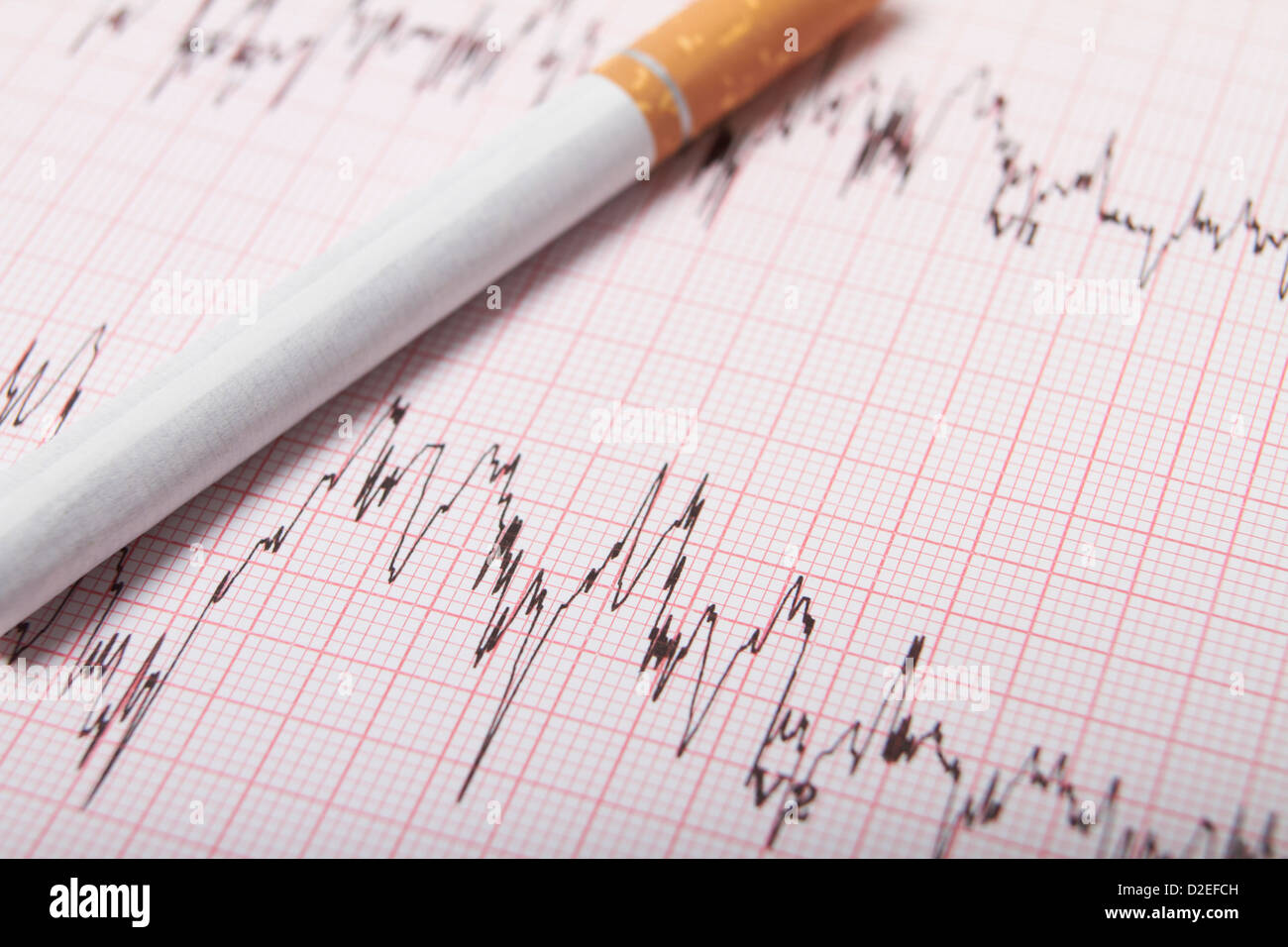 Zigarette auf EKG-Ausdruck Stockfoto