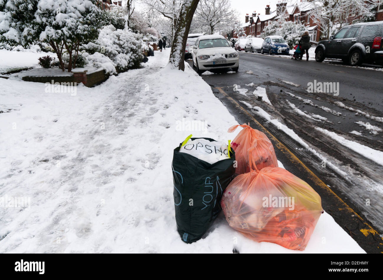 Müll-Sammlung an der Seite einer Vorstadt Straße im Schnee erwartet. Stockfoto