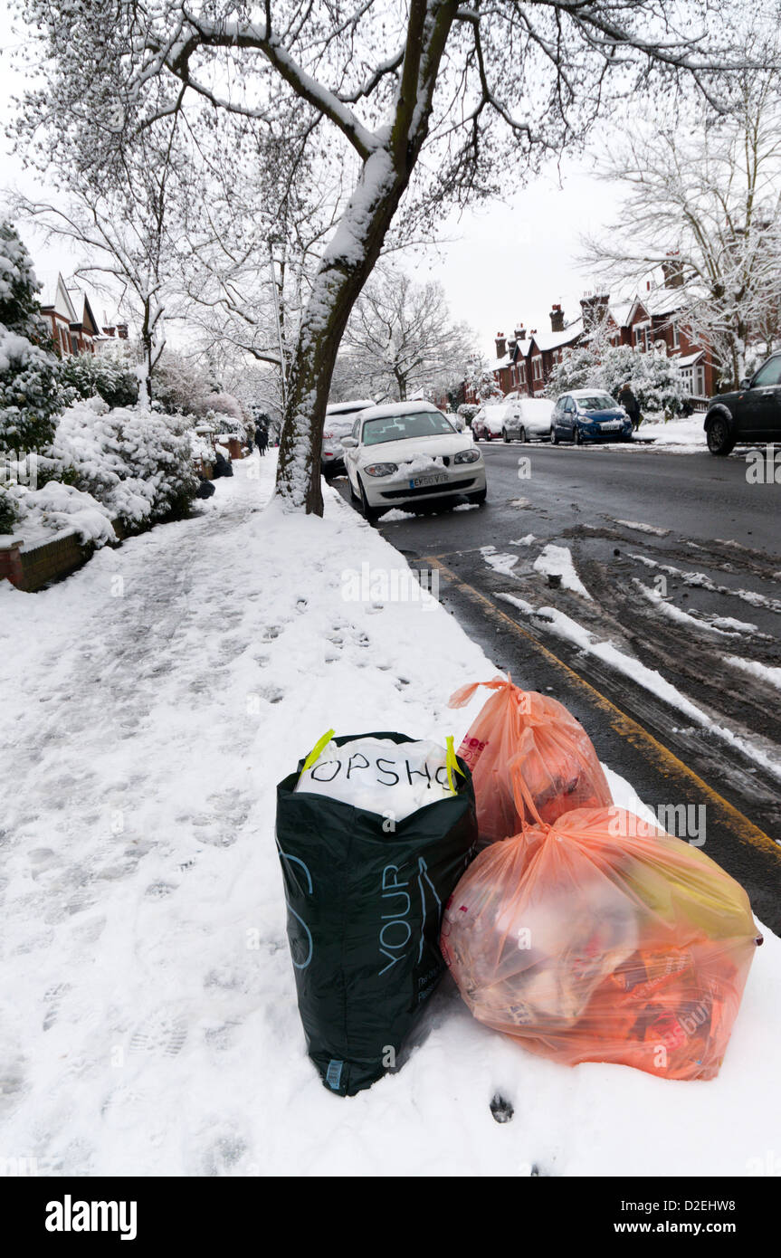 Müll-Sammlung an der Seite einer Vorstadt Straße im Schnee erwartet. Stockfoto