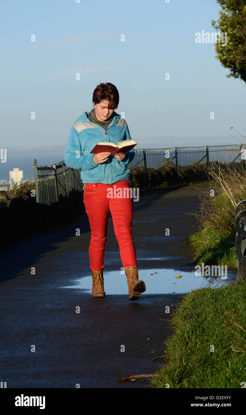 12 Jahr liest alte weißes Mädchen, während sie geht. Edinburgh, Schottland. Calton Hill Stockfoto