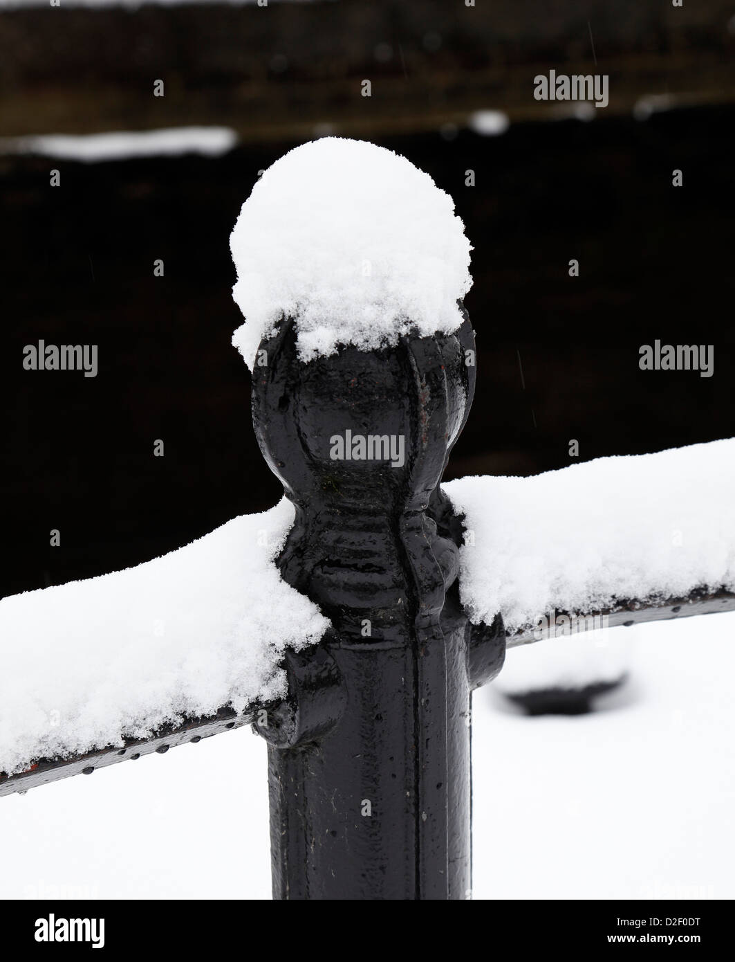 Metall-Zaun im Winter mit Schnee bedeckt. Stockfoto
