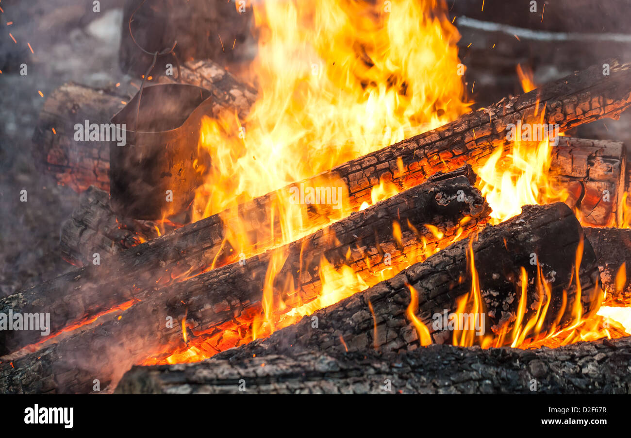 Brennen Sie Brennholz in Lagerfeuer mit Metall schwarz Wasserkocher Stockfoto