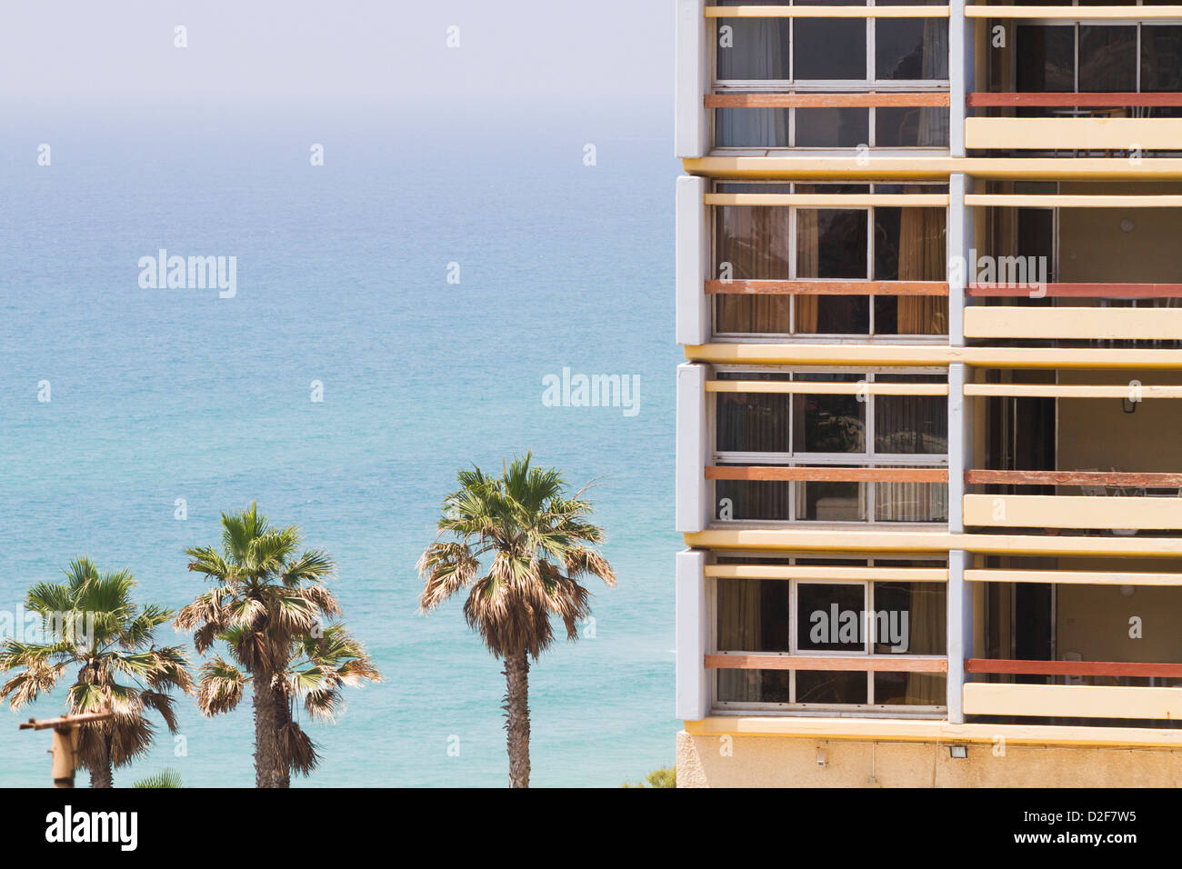 Ein Wohnblock in Tel Aviv, Israel, mit dem Mittelmeer im Hintergrund an einem sonnigen Tag. Stockfoto