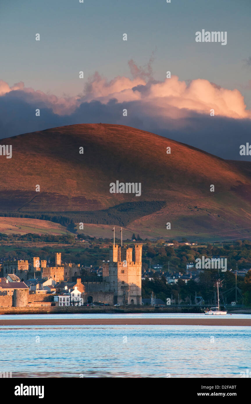 Caernarfon Castle und Menai Straits unterstützt von Moel Eilio gesehen von Anglesey, Gwynedd, Nordwales, UK Stockfoto