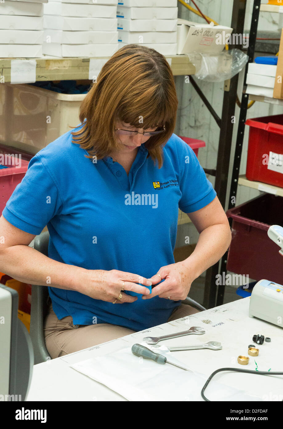 Frau, die Montage von elektrischer Schaltern in einer Fabrik Stockfoto