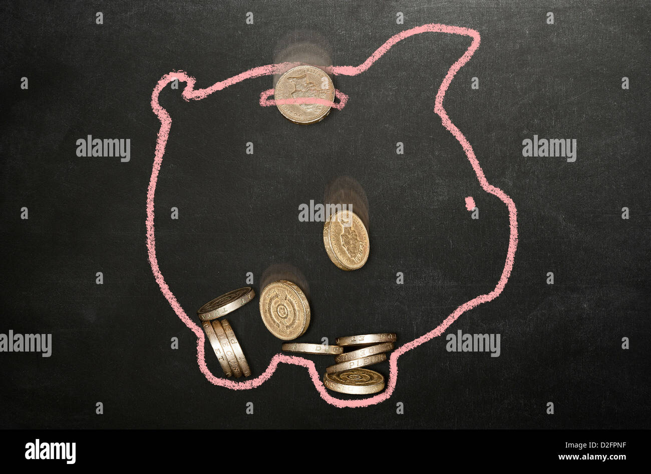 Sterling Pfund-Münzen fallen in der Kreide zeichnen Sparschwein auf eine Rückwand Stockfoto