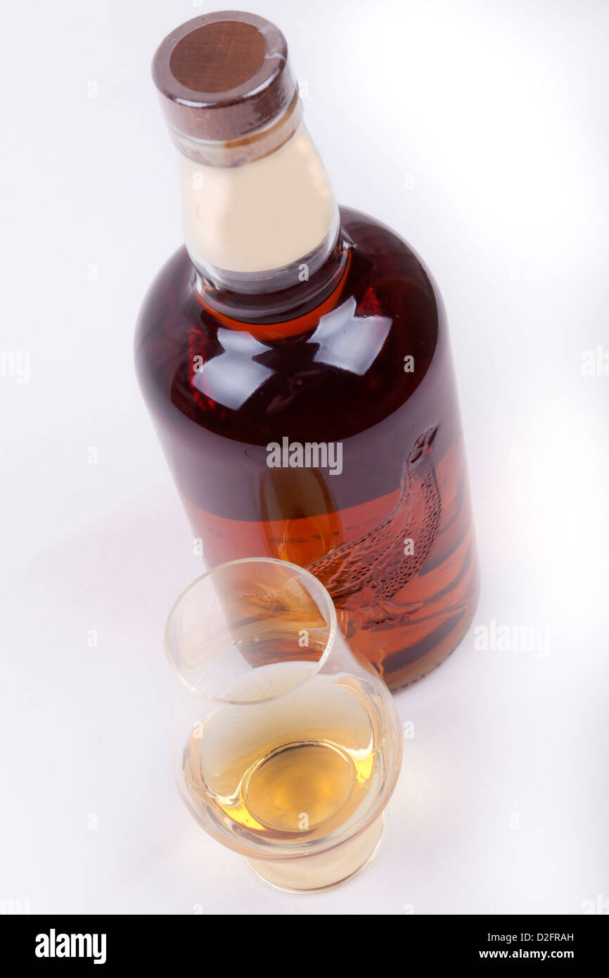 Glas und eine Flasche Whisky auf weißem Hintergrund Stockfoto
