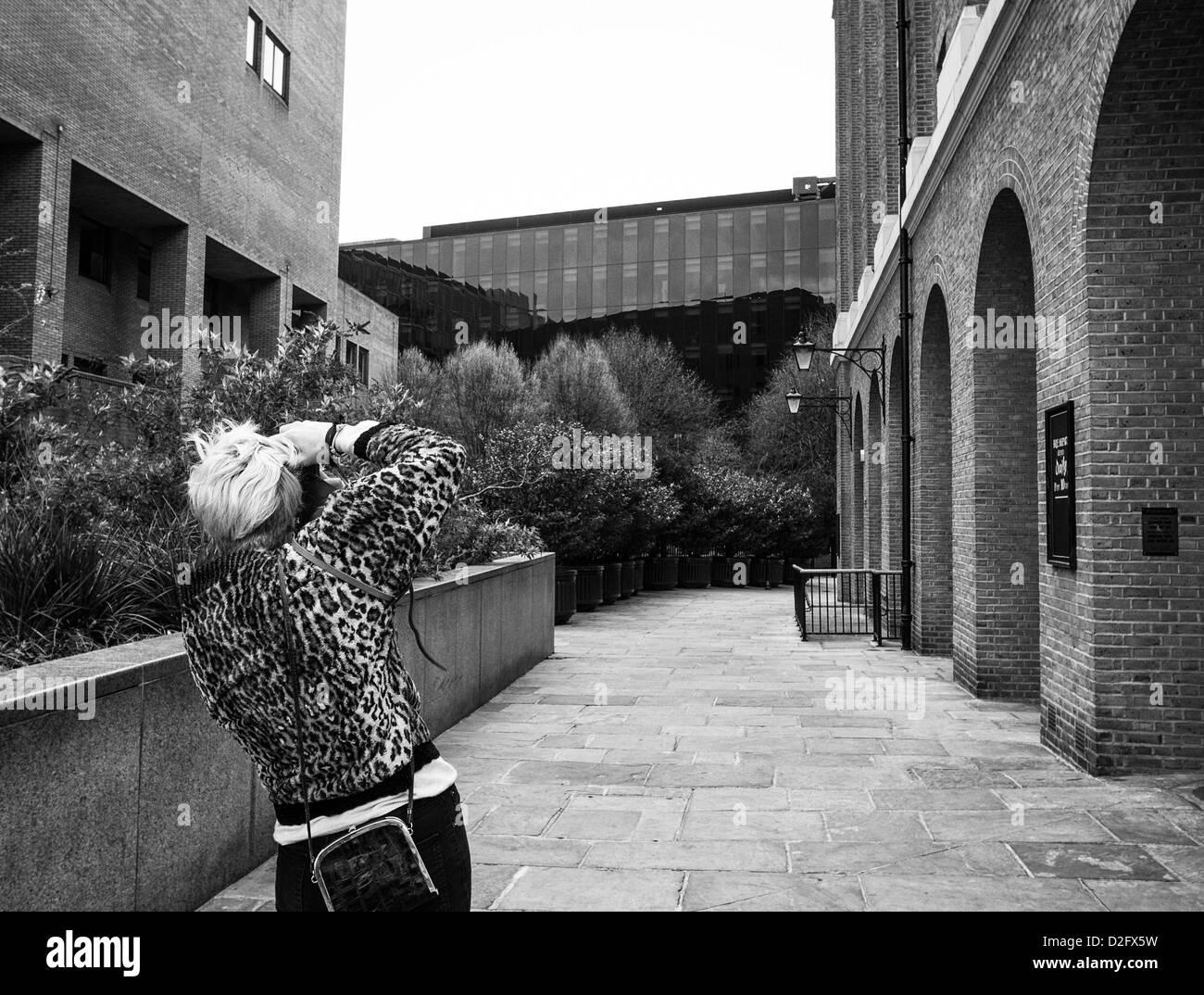 eine Bolnde Frau in Leopard skin Mantel mit Kamera fotografieren am rechten Ufer in London Stockfoto