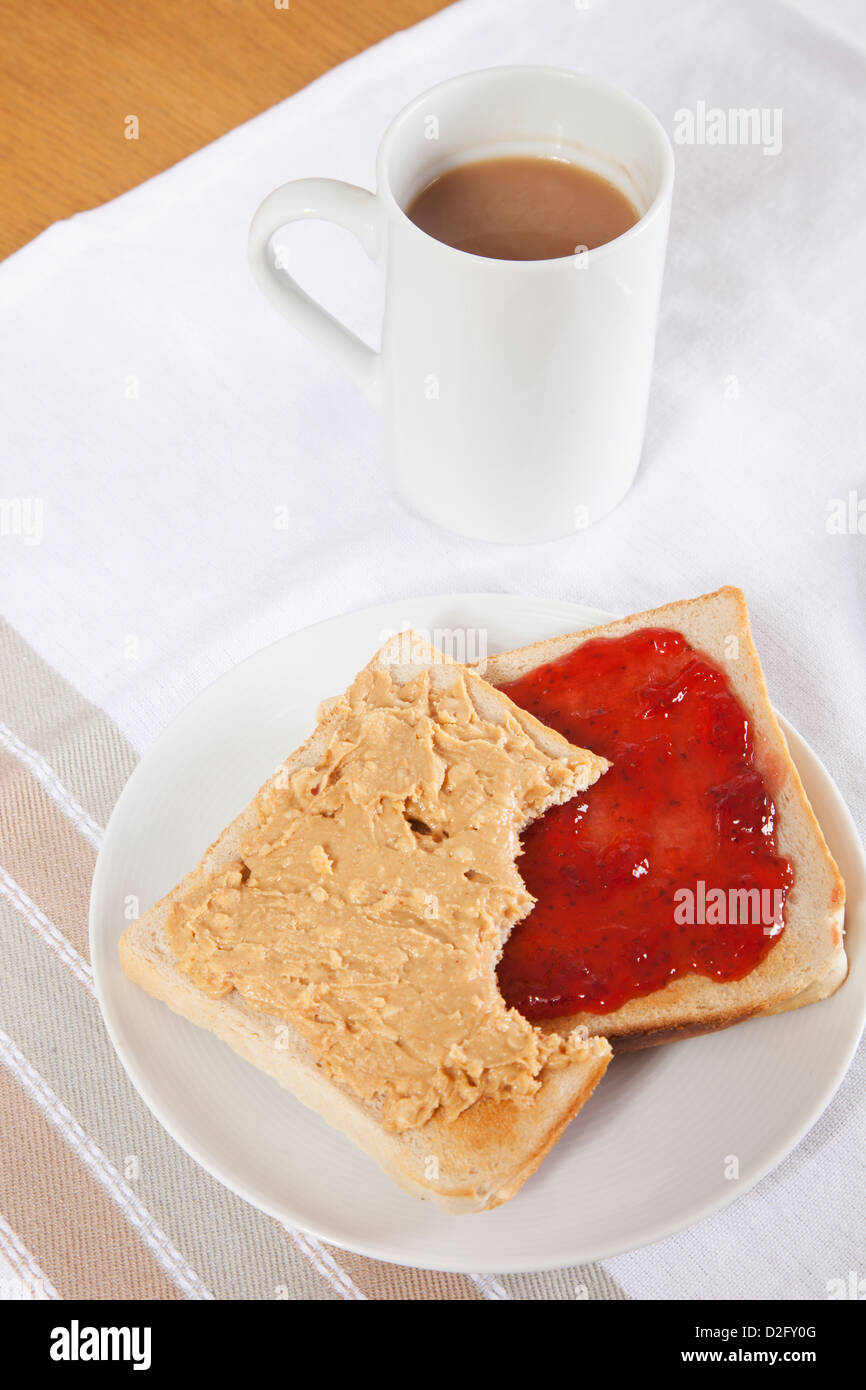 Erdnussbutter und Marmelade auf Brot mit Tasse Kaffee Stockfoto