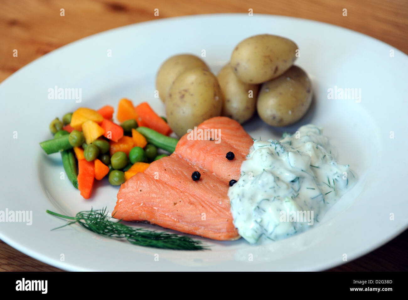 Eine gesunde Mahlzeit aus geräuchertem Lachs, neue Kartoffeln, Gemüse und Dill und Crème Fraîche Sauce gemischt Stockfoto