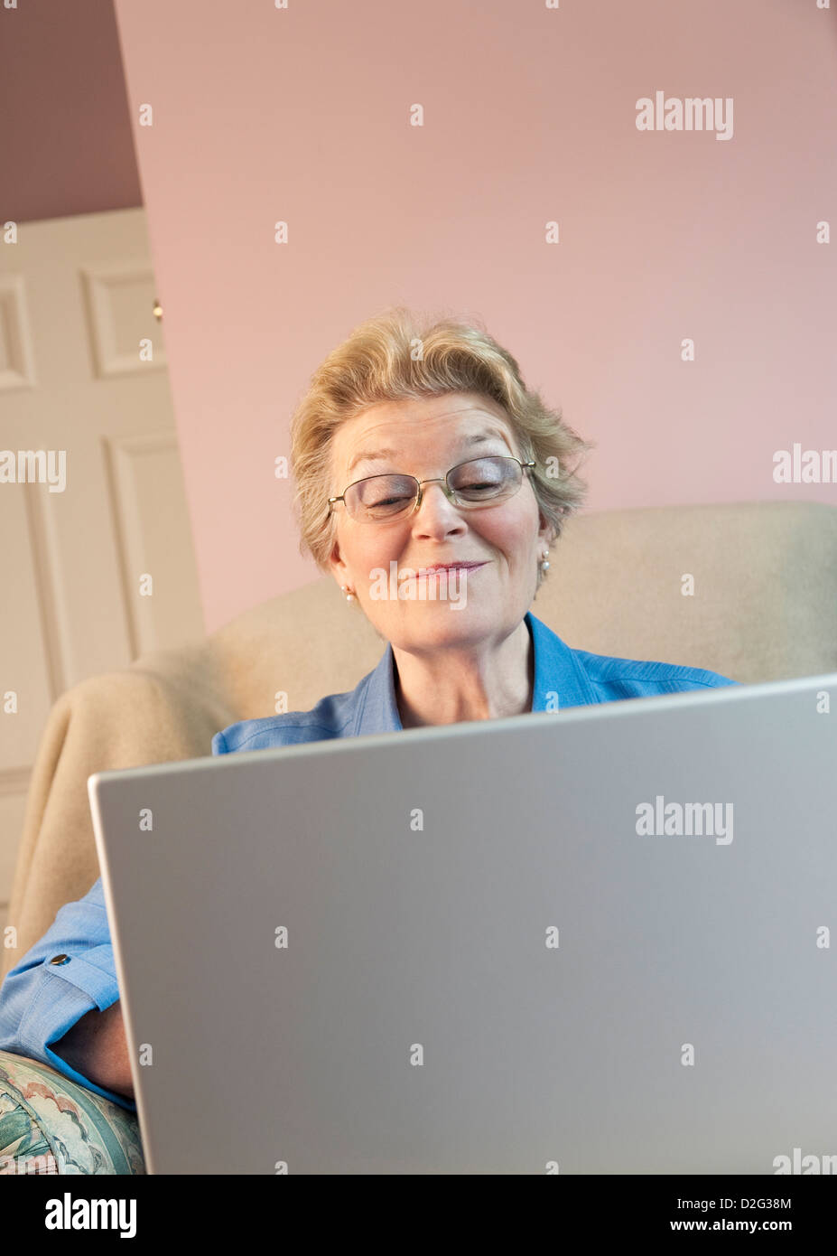 Ältere Frau mit Laptop und lächelnd Stockfoto