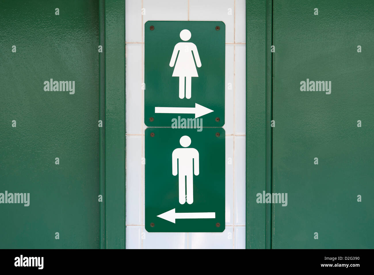 Grünes Schild mit männlichen und weiblichen Symbolen angewiesen, in entgegengesetzte Richtungen gehen Stockfoto