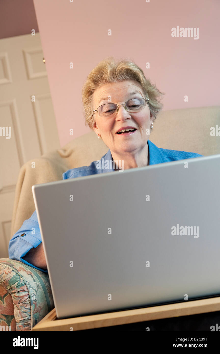 Reife Frau mit einem Laptop und lächelnd Stockfoto