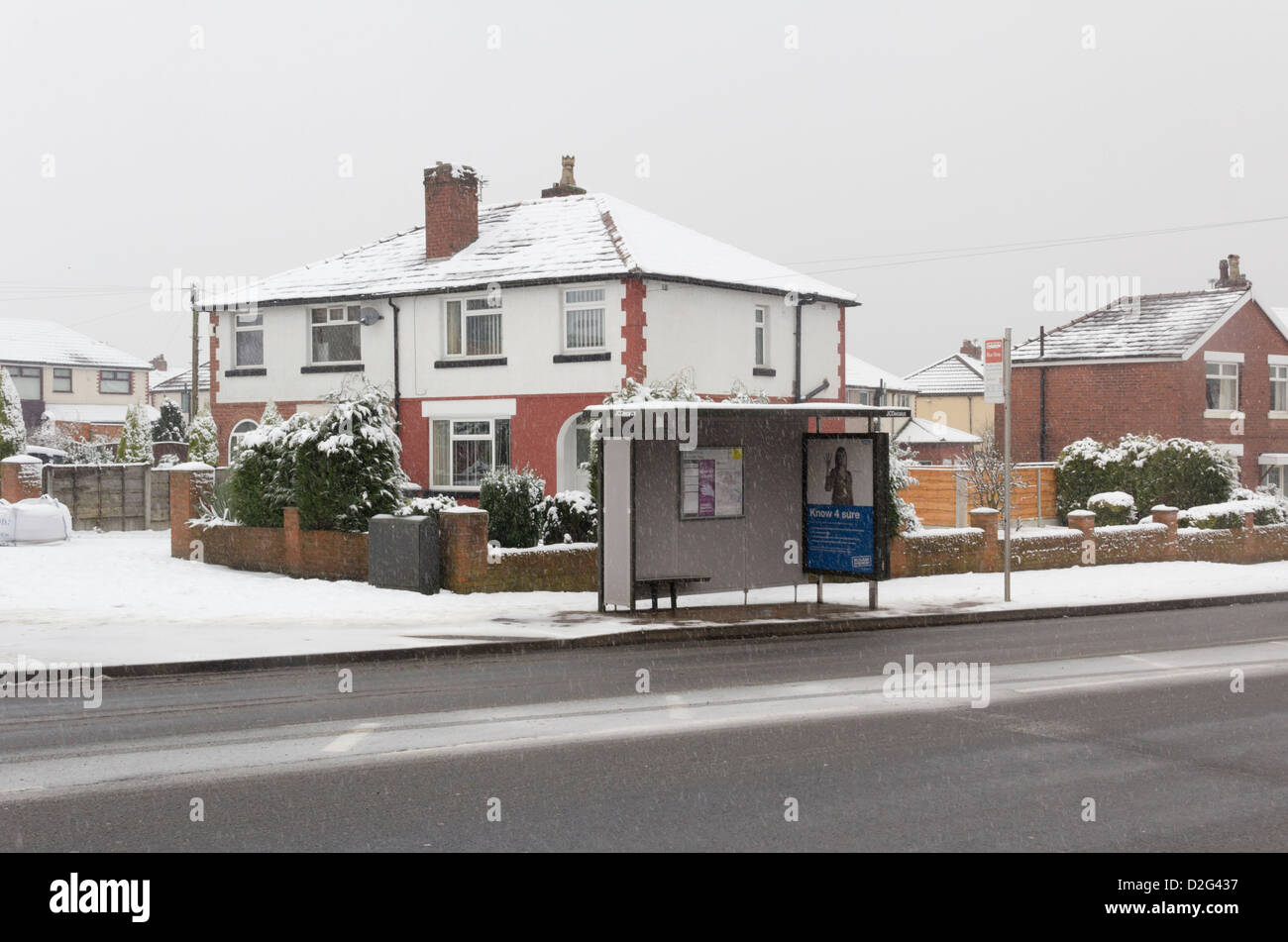 Eine Wartehalle mit niemand warten auf Bradford Road, Farnworth, im Winter mit liegender Schnee und leichtem Schnee fallen Stockfoto