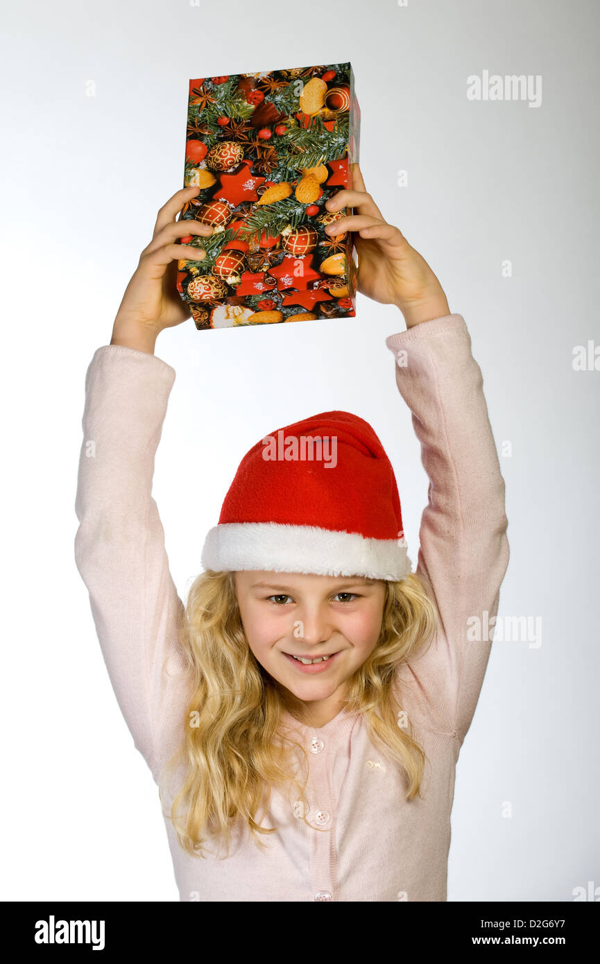 Berlin, Deutschland, das kleine Mädchen mit Weihnachts-Geschenk und Nikolausmuetze Stockfoto