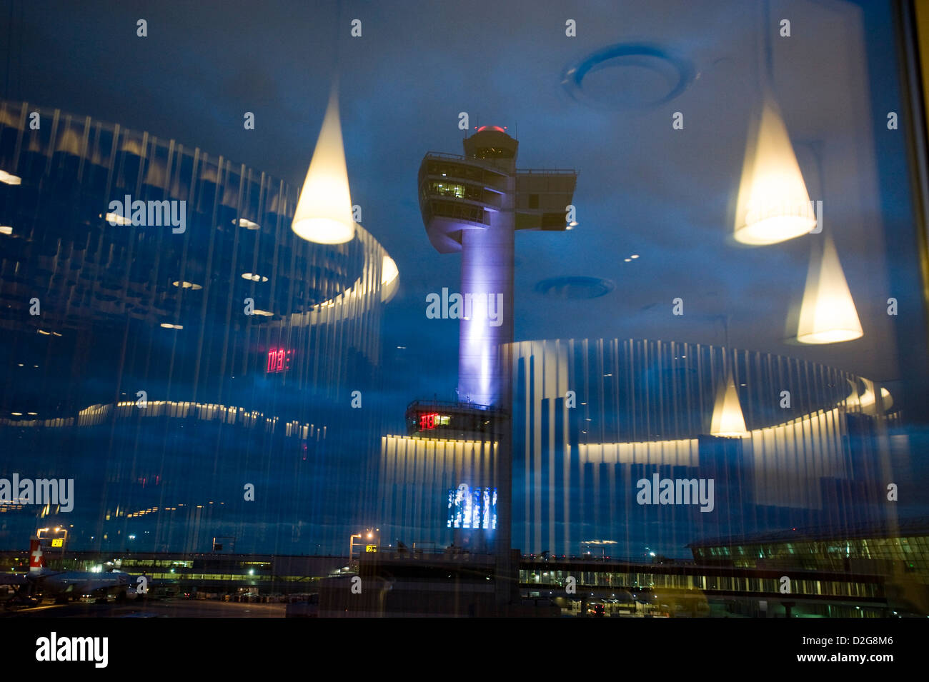 Der Kontrollturm ist in der Abenddämmerung am John F. Kennedy Airport, JFK Airport, New York, USA beleuchtet. Fotografiert mit den Überlegungen von Lichtern in der Virgin Airways Upper Class lounge Stockfoto