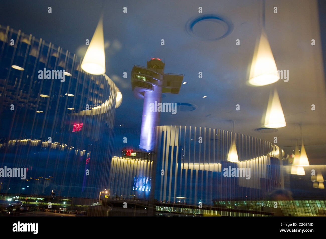 Der Kontrollturm ist in der Abenddämmerung am John F. Kennedy Airport, JFK Airport, New York, USA beleuchtet. Fotografiert mit den Überlegungen von Lichtern in der Virgin Airways Upper Class Lounge. Stockfoto