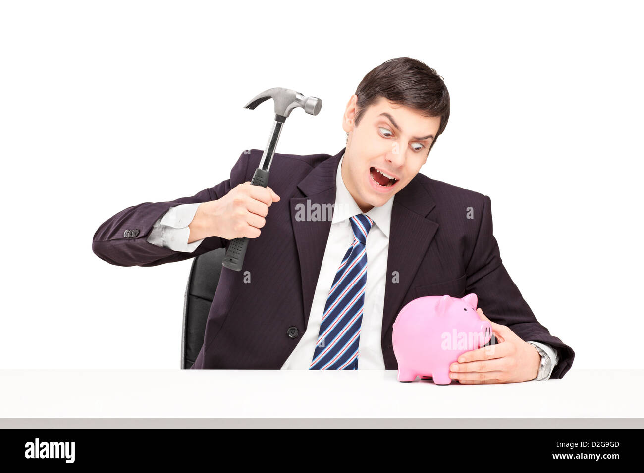 Gereizter Mann versucht zu brechen ein Sparschwein mit einem Hammer isoliert auf weißem Hintergrund Stockfoto