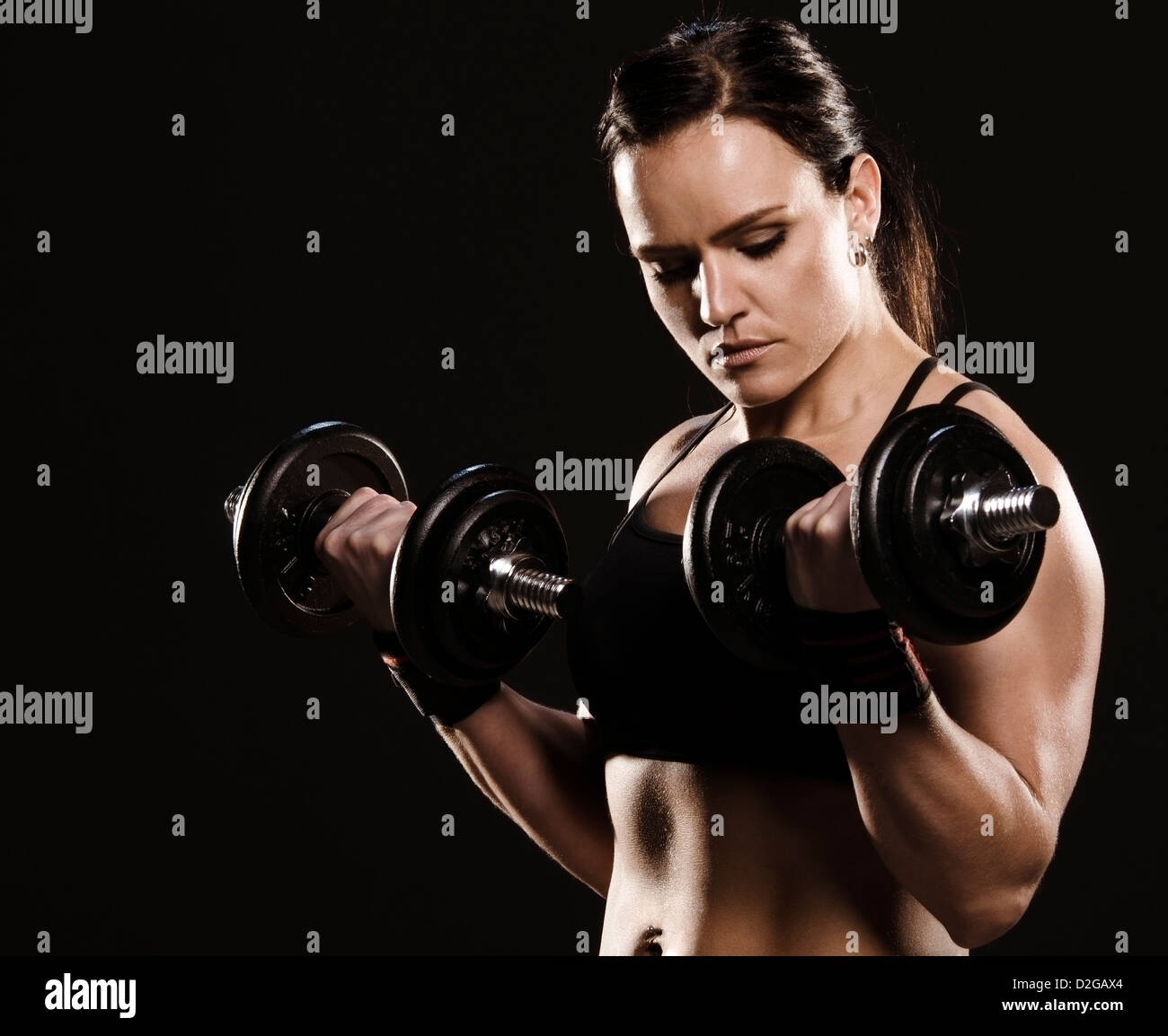 Schöne muskulöse Frau dabei eine Bizeps Training mit Hanteln. Stockfoto