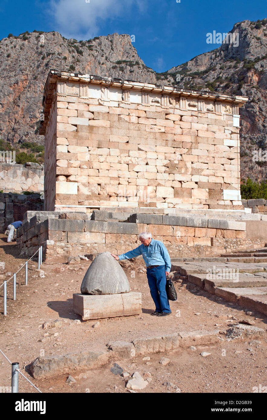 Touristischen berühren der Omphalos, manchmal bekannt als "Nabel der Welt" in den Ruinen von Delphi; Griechenland Stockfoto