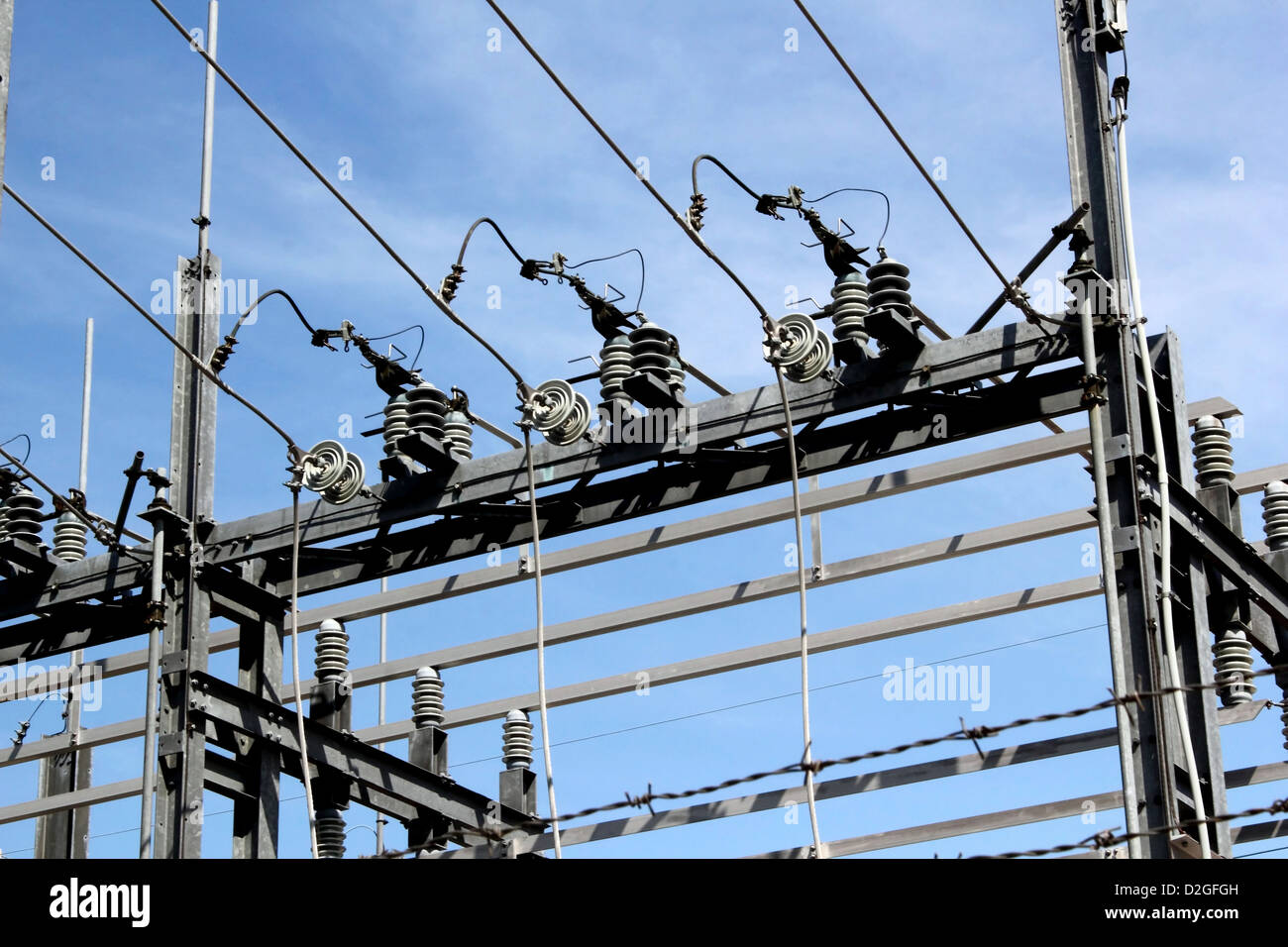 Stahlbau, Drähte, Spulen und Kabel eines elektrischen Kraftwerks vor blauem Himmel. Stockfoto