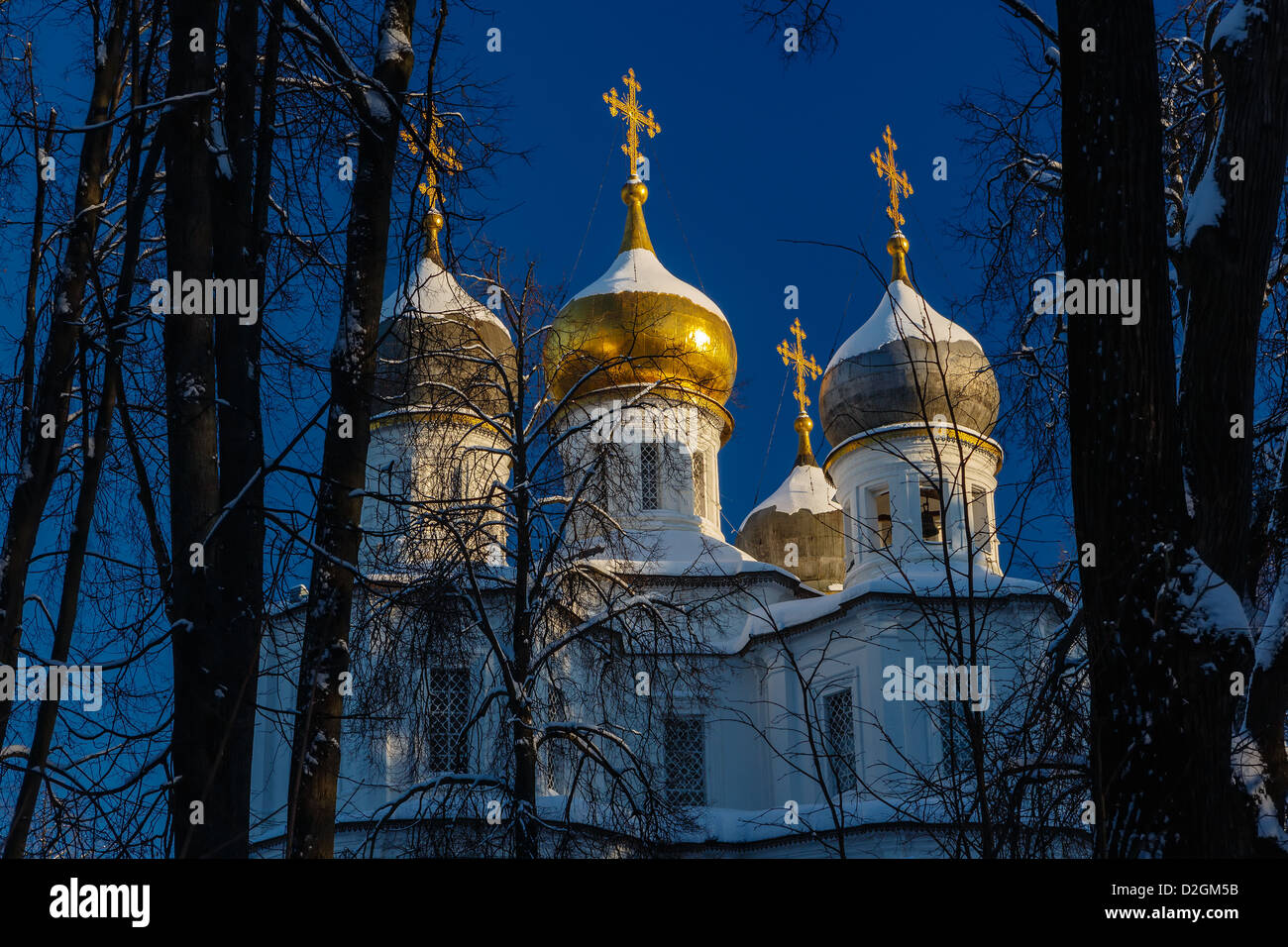 Orthodoxe Kirche mit vergoldeten Kuppeln und Kreuze im Rahmen von Bäumen Stockfoto