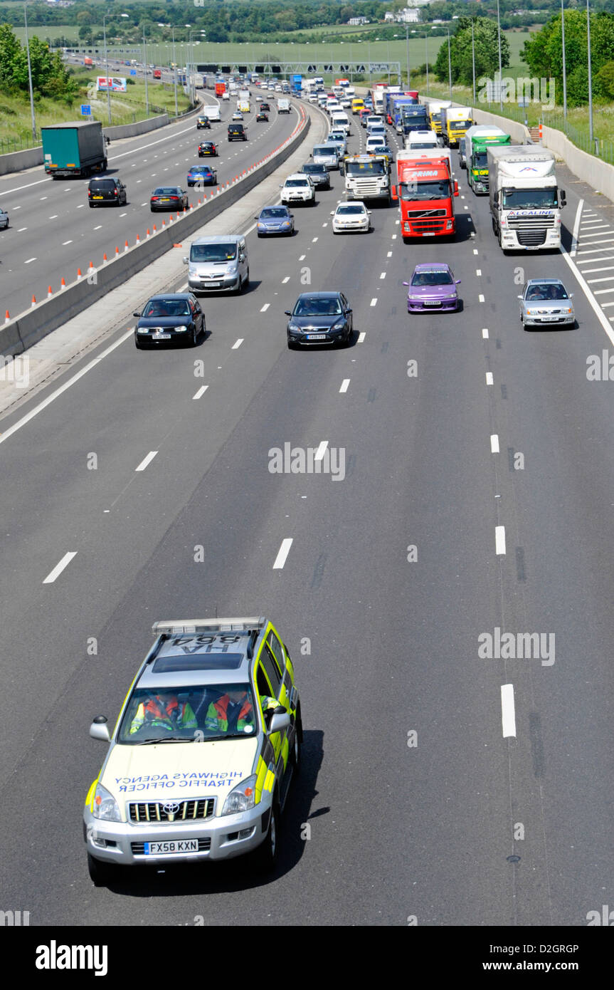Blick von oben der Highways Agency Auto mit Verkehr Offiziere Betrieb eines Rolling Road Block von langsam fahrenden Verkehr auf Autobahn M25 Essex England Großbritannien Stockfoto