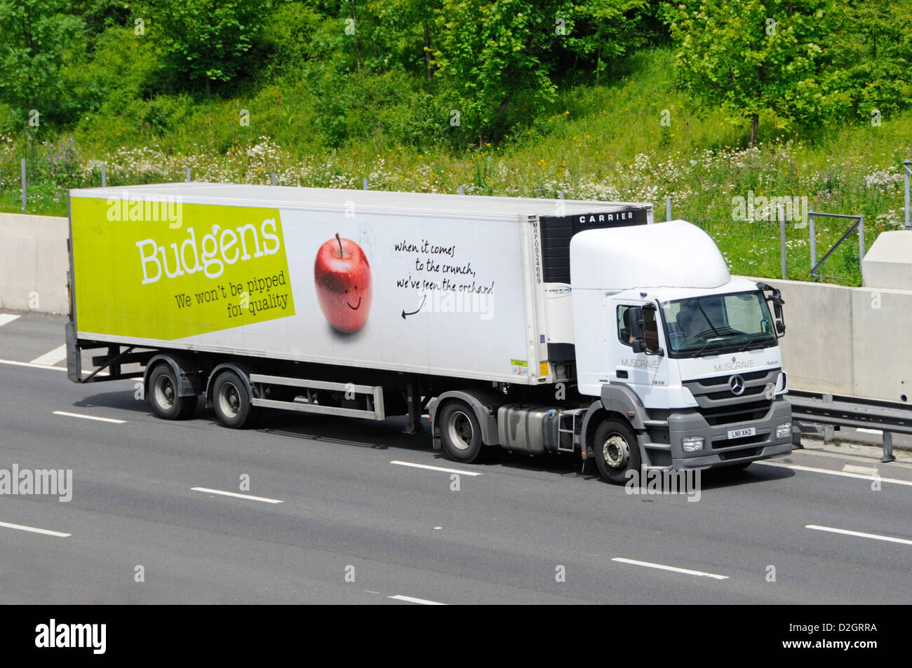Side View lkw Supermarkt Lebensmittelversorgungskette Laden Lieferung LKW mit Anhänger Budgens Geschäft Werbung für britische Kartoffeln auf der UK M25 Autobahn Stockfoto