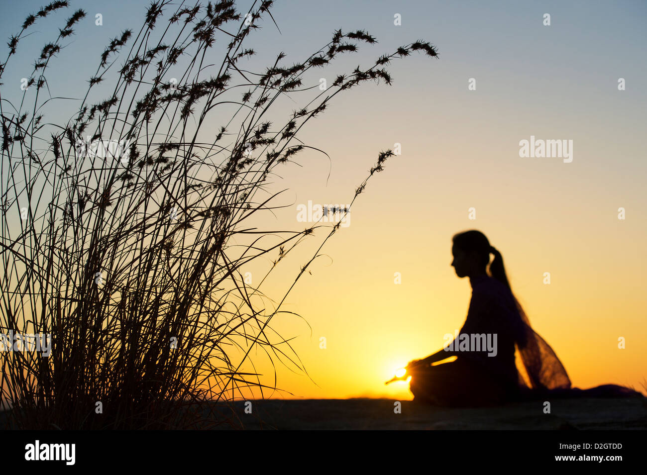 Sonnenuntergang Silhouette eines indischen Mädchen meditieren. Andhra Pradesh, Indien Stockfoto