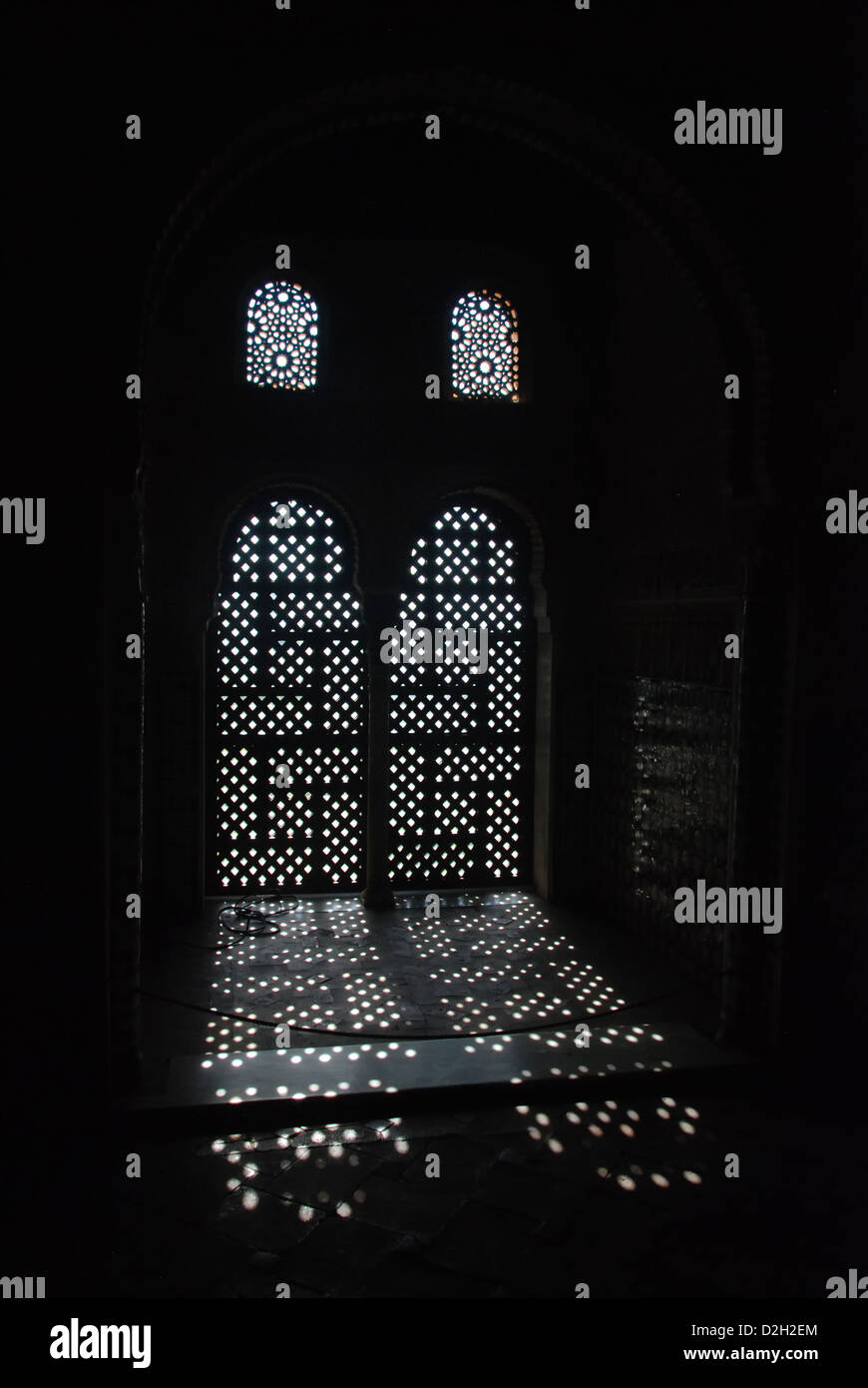 Licht in dunklen Raum durch einen maurischen Fenster der Alhambra in Grenada Stockfoto