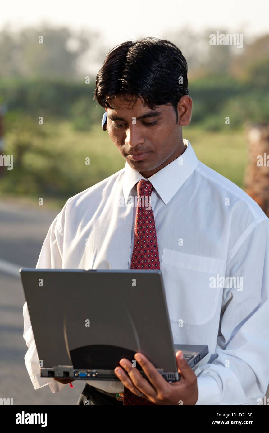 Indien, Uttar Pradesh, Agra indischer Geschäftsmann mit Laptop und Bluetooth-Kopfhörer tragen Stockfoto