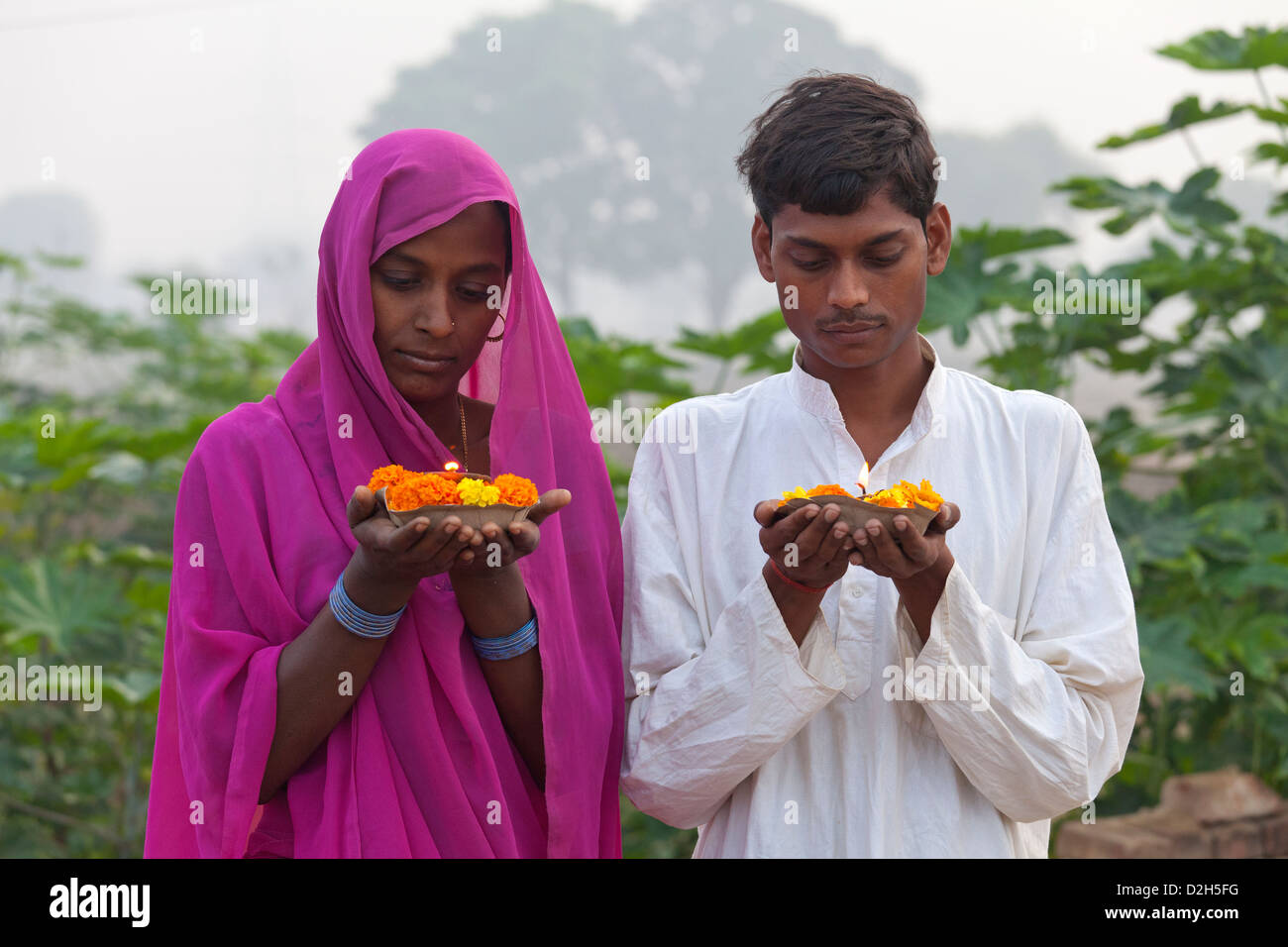 Indien, Uttar Pradesh, jungen hindu Mann und Frau mit Gebet Lampe und Ringelblumen Stockfoto