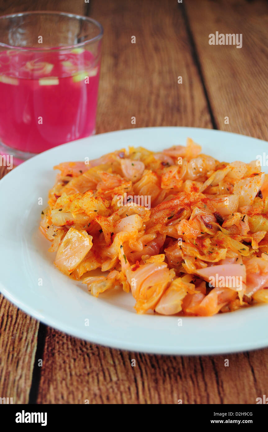 Sauerkrautsalat mit Paprika, Glas Saft auf der Seite Stockfoto
