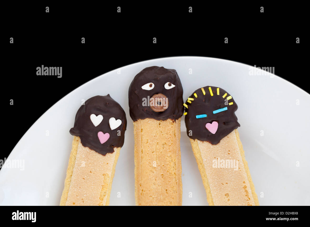 Drei Löffelbiskuit Kuchen verziert als Familie. Stockfoto