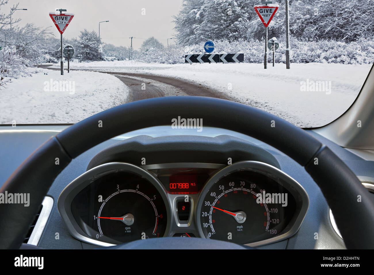 Autofahrer Sicht durch die Windschutzscheibe des Fahrzeugs während der Fahrt auf dem Schnee bedeckt Straße Stockfoto
