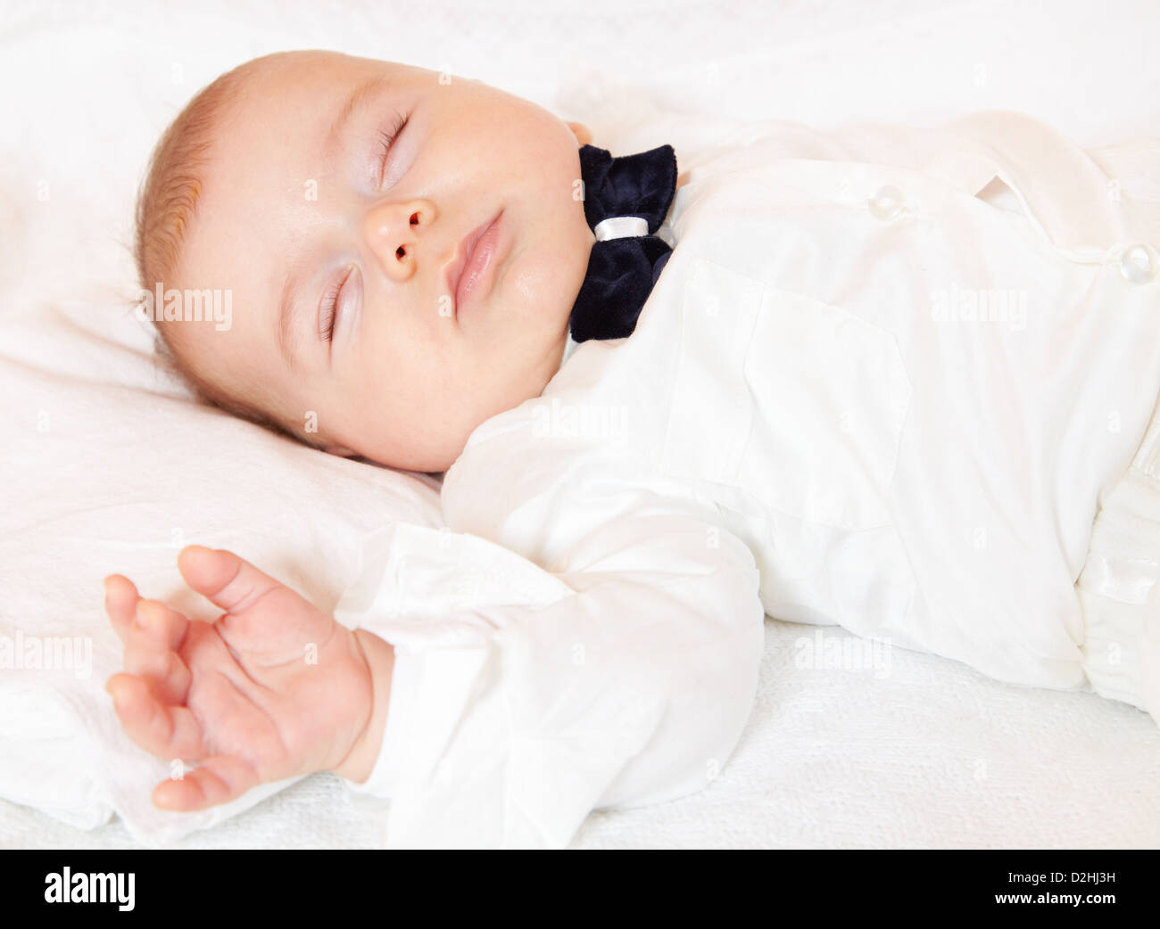 Baby Junge gekleidet für Party friedlich schlafend. Stockfoto