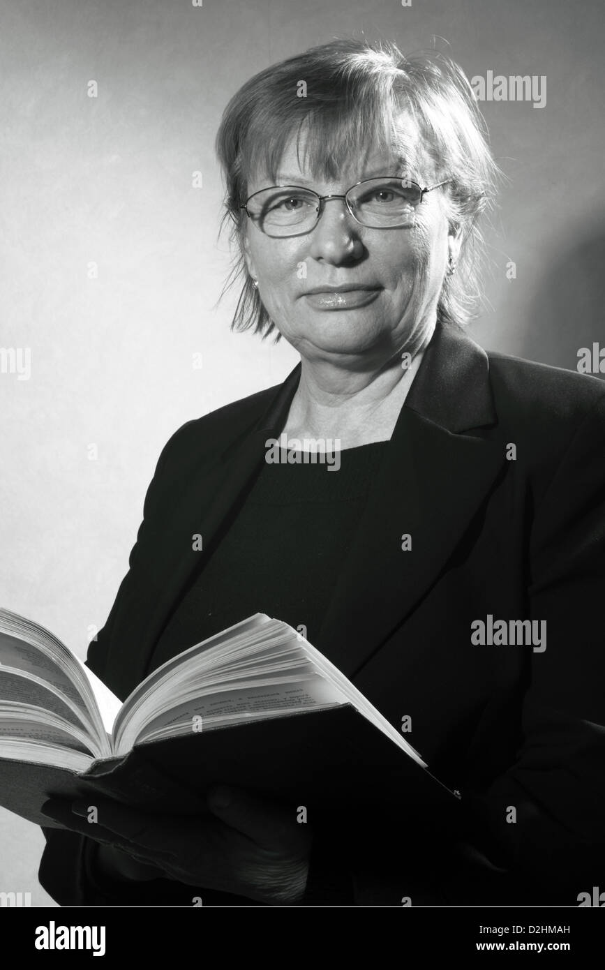 schwarz / weiss Portrait mittlere gealterte Frau in Brillen mit Buch Stockfoto