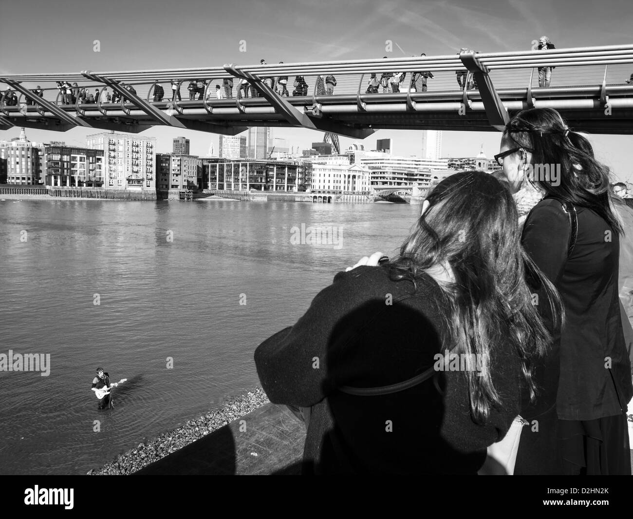 ein Junge spielt auf der Gitarre in Thames unter Millennium bridge Stockfoto