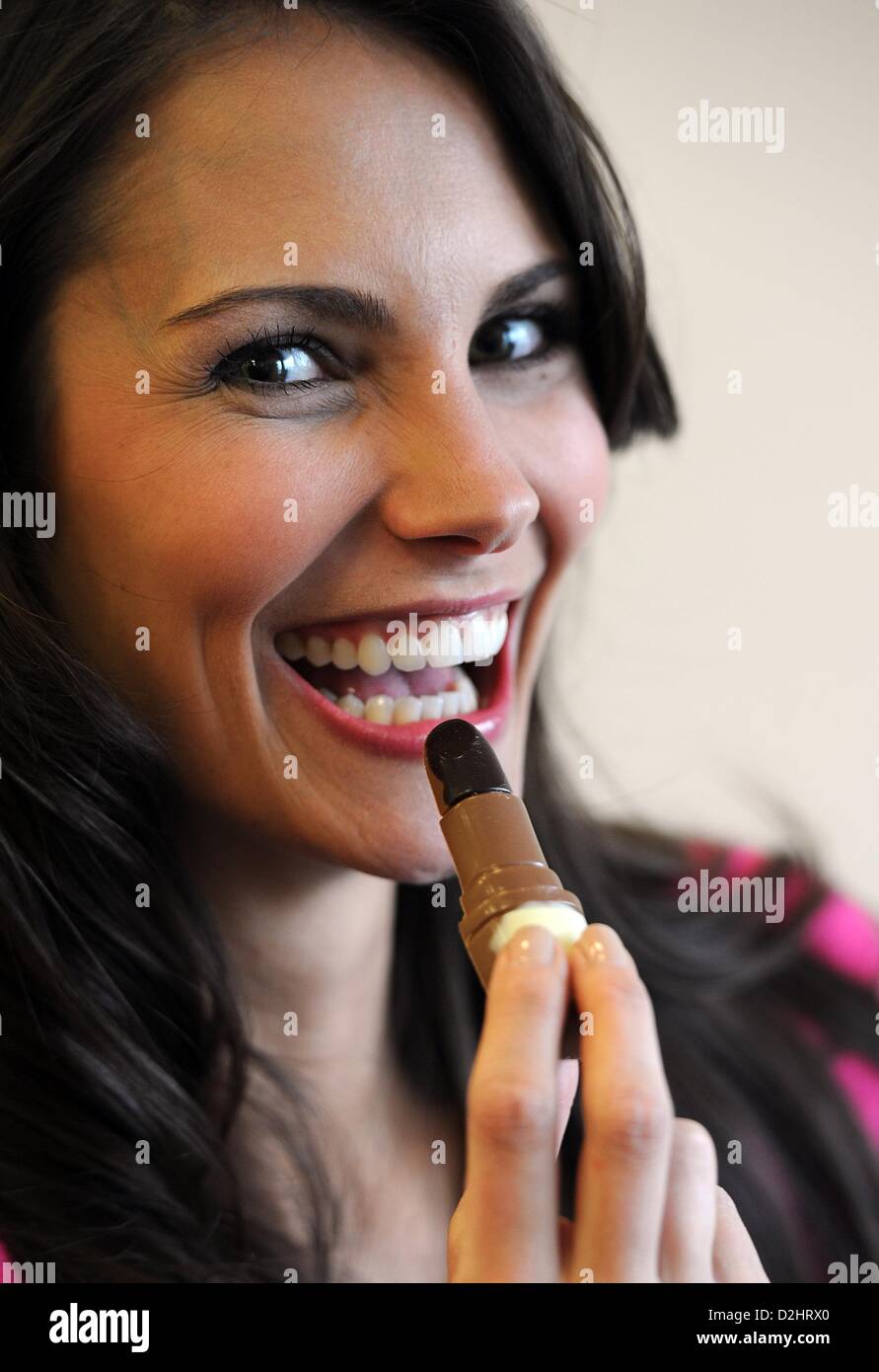 Ein Modell der Lippenstift-förmigen Schokoriegel beißt "Girls - Schokolade für Frauen" (Heilemann) an der internationalen Süßwaren Handel Messe ISM in Köln, Deutschland, 25. Januar 2013.  Die Messe läuft vom 27. bis Januar 2013. Foto: HENNING KAISER Stockfoto