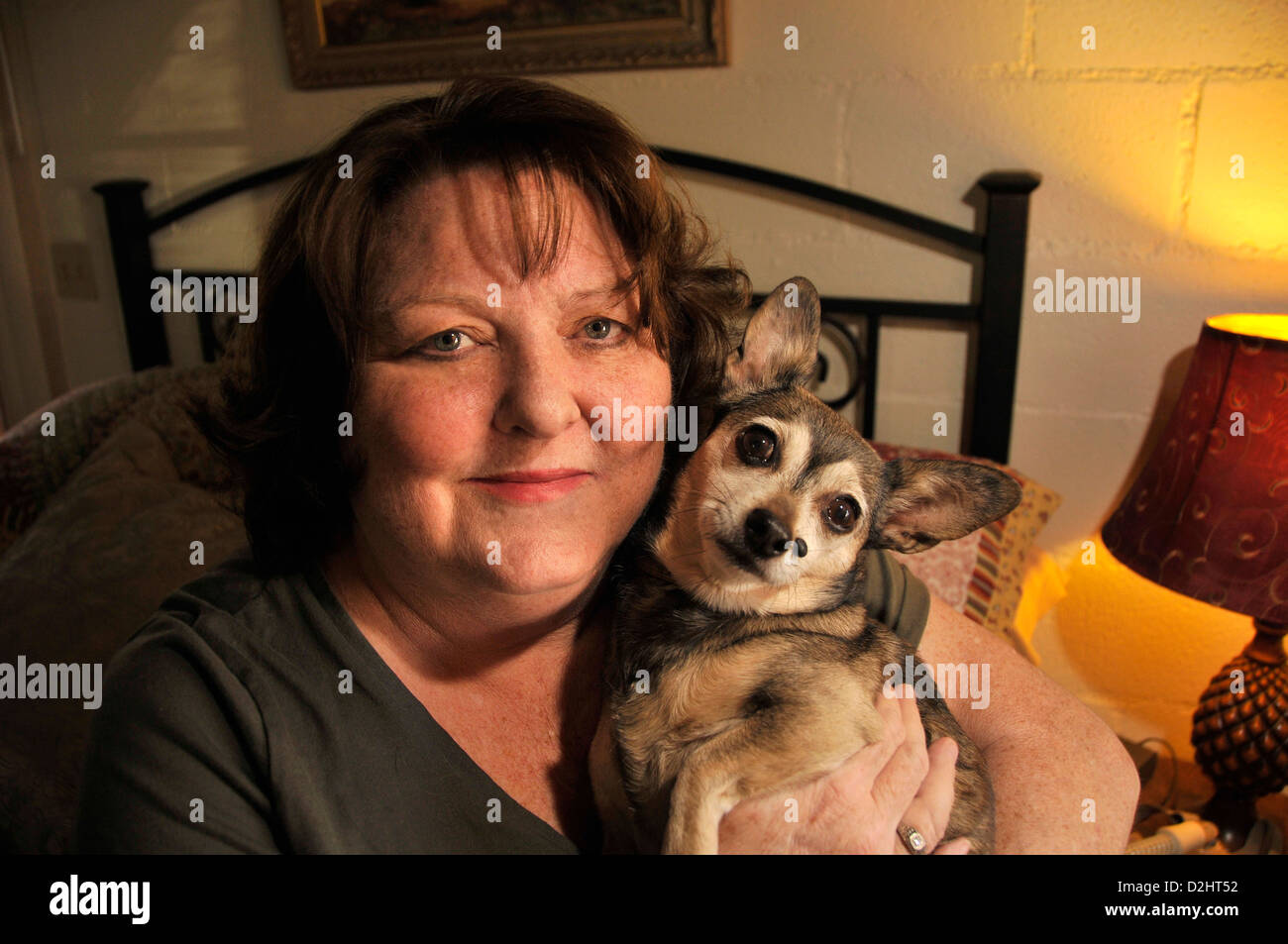 Chronisch Kranken senior hält ihr Haustieren Hund. Stockfoto